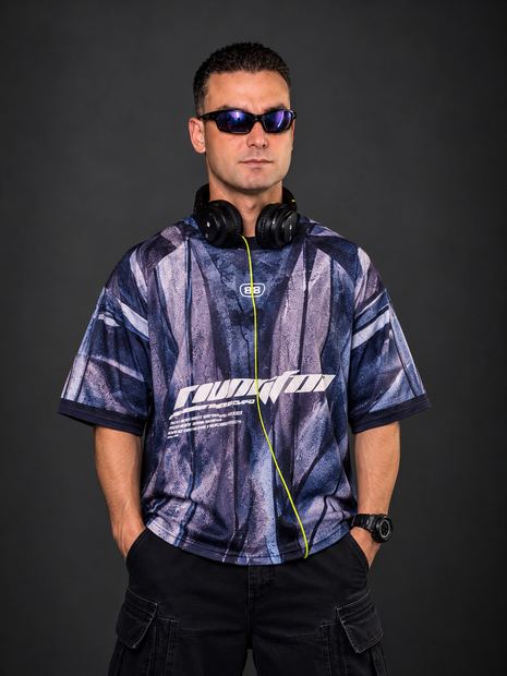 DJ TH de perfil, braços cruzados