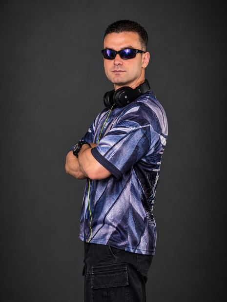 DJ TH de perfil, com fones no pescoço